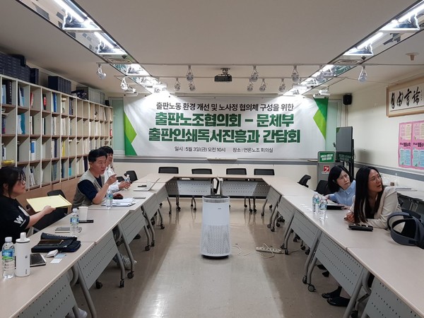  3일 언론노조 회의실에서 진행된 '출판노동 환경 개선 및 노사정 협의체 구성을 위한 간담회'에서 참가자들이 벽에 걸린 언론노조 창립총회 사진을 함께 보고 있다 